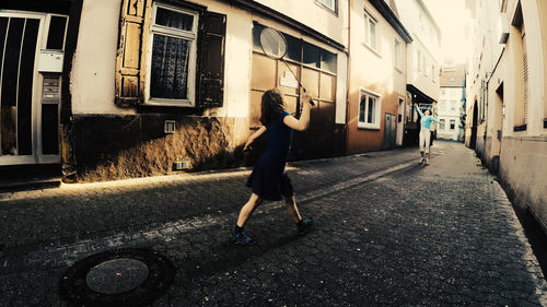 Girls playing badminton at alley