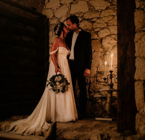 Young newlyweds kissing by candle light.