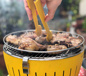 Close-up of person preparing food on barbecue grill