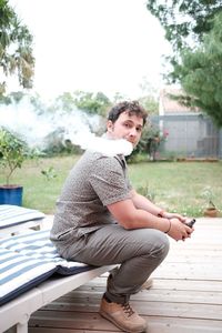 Side view of young man sitting on seat