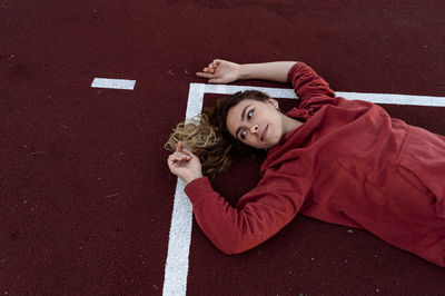 High angle view of woman lying on sports court