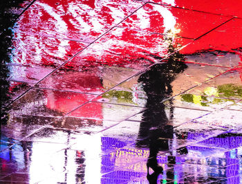 Low section of woman with umbrella during rainy season