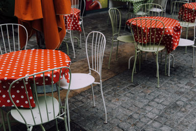 Empty chairs and tables at sidewalk cafe