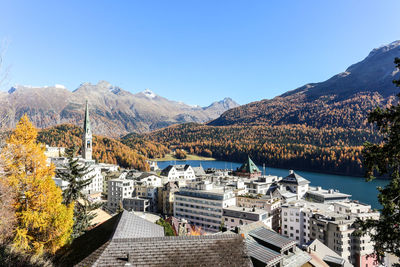 Panoramic shot of buildings and mountains against clear blue sky