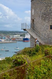 Scenic view of sea by buildings against sky