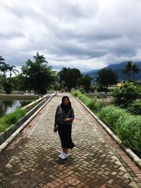 Rear view of man standing on footpath against sky