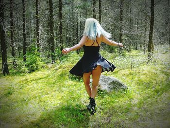 Woman walking on field in forest