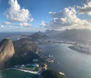 Aerial view of city by sea against sky