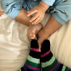 Low section of mother and daughter on bed