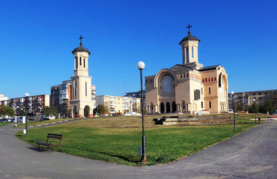 Street by buildings against clear blue sky