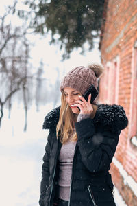 Woman standing on snow covered tree during winter