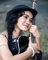 Close-up portrait of smiling young woman playing outdoors