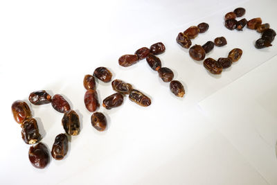 High angle view of coffee beans against white background