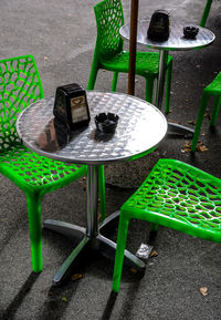 High angle view of empty chairs and table at sidewalk cafe