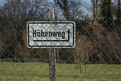 Information sign on wood behind chainlink fence