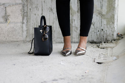 Low section of woman with bag standing on floor