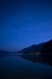 Scenic view of lake against blue sky at night