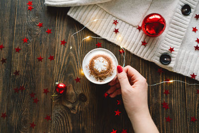 Christmas cup of coffee with sweater and christmas decorations.