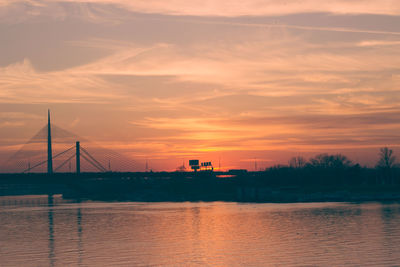 Bridge over river against sky during sunset