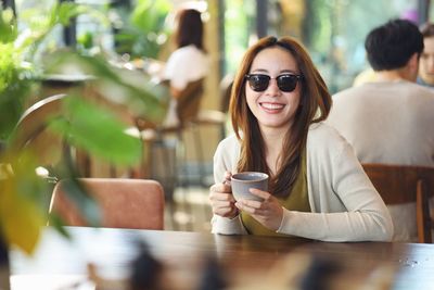 Portrait of young woman having drink in cafe