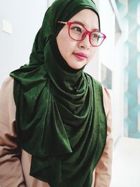 Woman wearing hijab and eyeglasses looking away in city