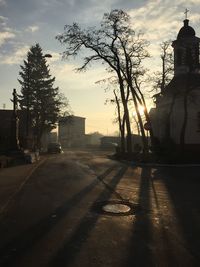 Road by church against sky at morning