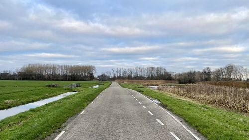 Surface level of road on field against sky