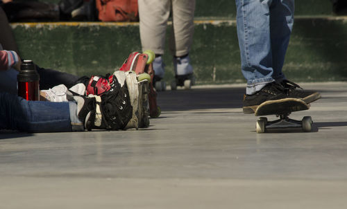 Low section of man skateboarding by people outdoors