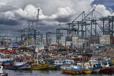 Boats moored at harbor against sky