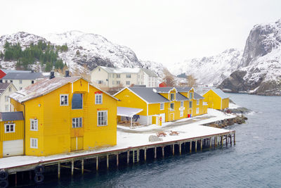 Built structures on snow covered mountain against sky