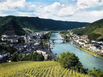 Scenic view of river by townscape against sky