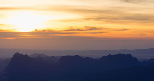 Scenic view of silhouette mountains against sky at sunset