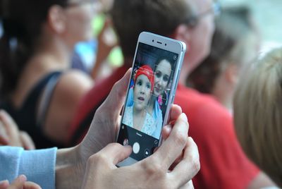 Close-up of woman taking selfie from mobile phone with daughter