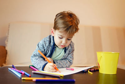 Boy sitting on table at home