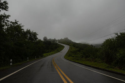 Countryside road passing through the lush green tropical rain forest mountain landscape