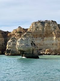 Rock formations in sea against sky