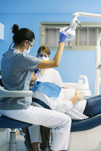 Dentists examining pregnant woman in clinic