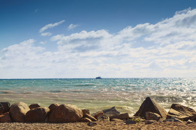 Distant view of boat in sea against sky