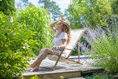 Low angle view of young woman sitting on wooden table