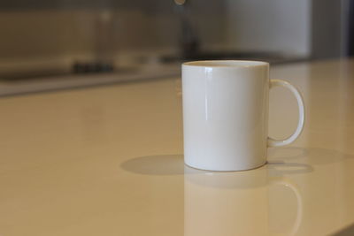 Close-up of coffee cup on table at home