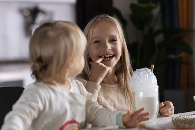 Portrait of cute girl blowing bubbles at home