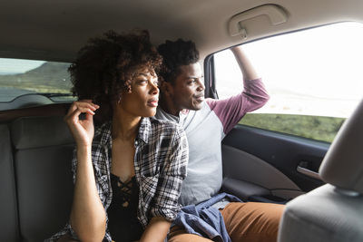 Couple looking through window while traveling in car