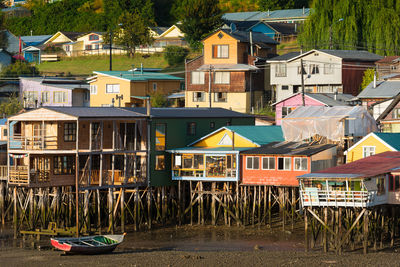 Boats moored on canal by houses against buildings