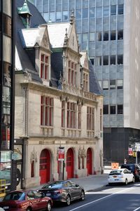 Cars on road by buildings in city