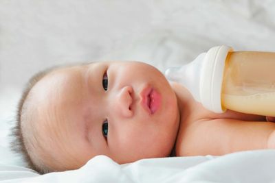 Close-up of baby boy with milk bottle