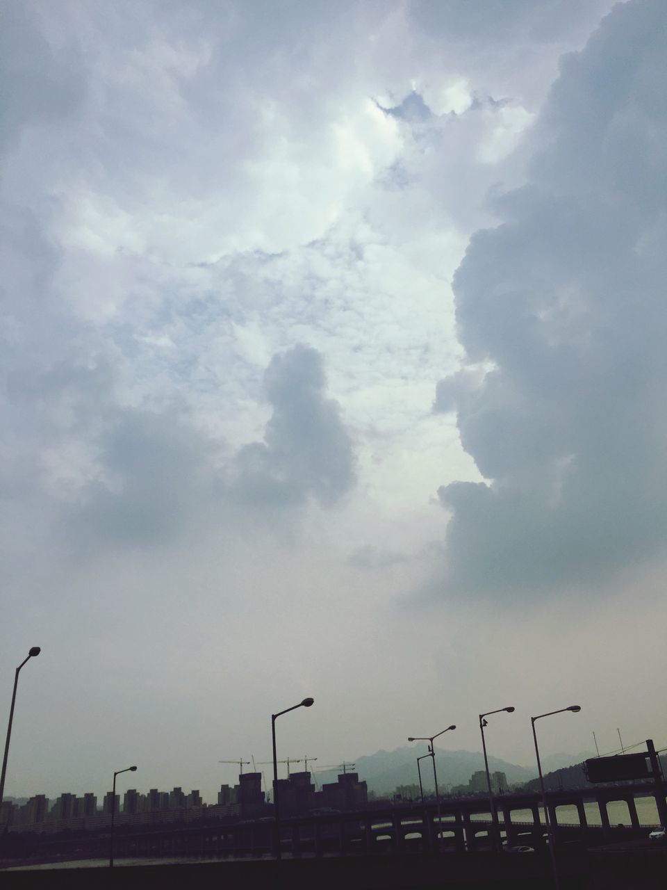 sky, cloud - sky, built structure, architecture, cloudy, building exterior, low angle view, cloud, city, weather, silhouette, overcast, outdoors, crane - construction machinery, no people, nature, development, dusk, day, industry