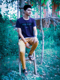 Full length of young man looking away in forest