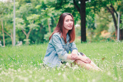 Beautiful young woman on grass in field