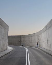 Rear view of man on road against clear sky