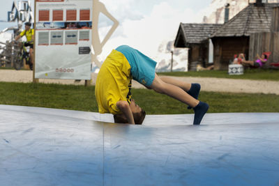 Boy trying to do headstand at yard